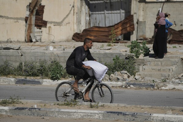 Palestinians carry bags of flour after storming a U.N. World Food Program warehouse in Zawaida, Central Gaza Strip, on Wednesday, May 28, 2025. (AP Photo/Abdel Kareem Hana)