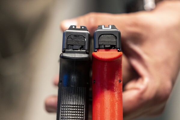 Two semi-automatic pistols are displayed for a photograph, one with a conversion device installed making it fully automatic, at the Bureau of Alcohol, Tobacco, Firearms, and Explosives (ATF), National Services Center, Thursday, March 2, 2023, in Martinsburg, W.Va. (AP Photo/Alex Brandon, File)